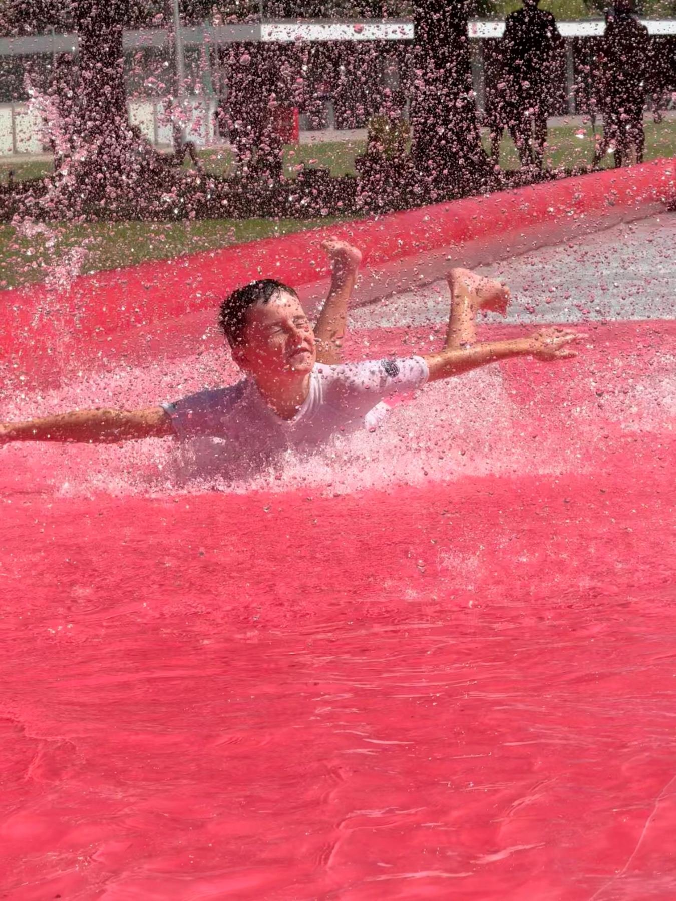 Kind auf der Wasserrutschbahn im Judocamp